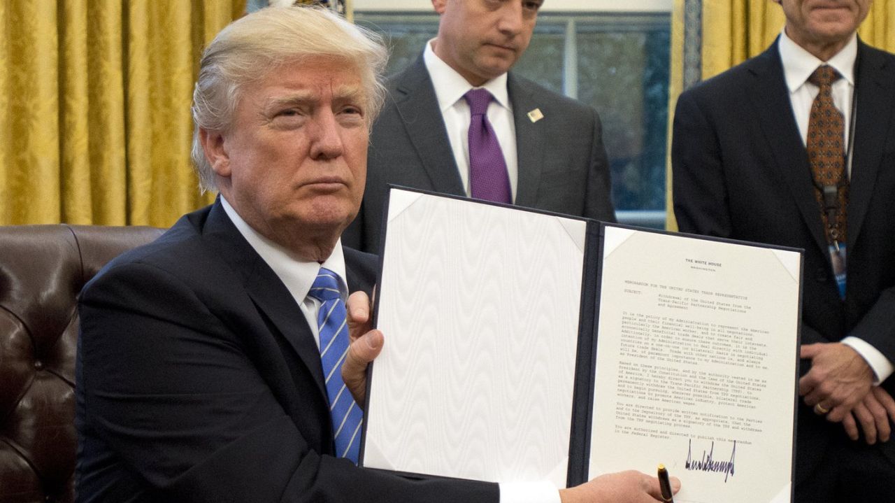 Prezident USA Donald Trump ukazuje médiím podpis pod listinou o odstoupení od smlouvy TPP. Zdroj: Reuters.com